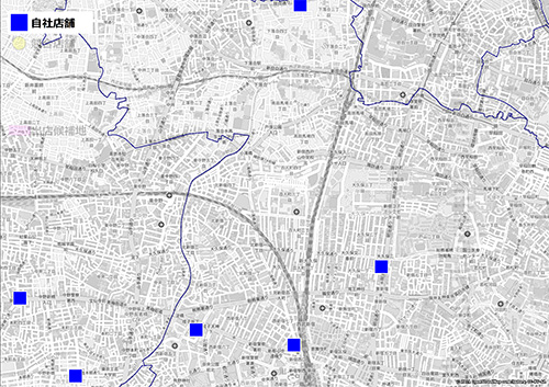 地図上に自社店舗の位置を示す青色の四角形が配置されている地図。地図には複数の自社店舗があり、特定のエリアが青い線で囲まれている。このエリアは店舗の営業範囲またはターゲットエリアを示している可能性が高い。背景は白黒の詳細な都市地図で、主要な道路や地名が表示されている。
